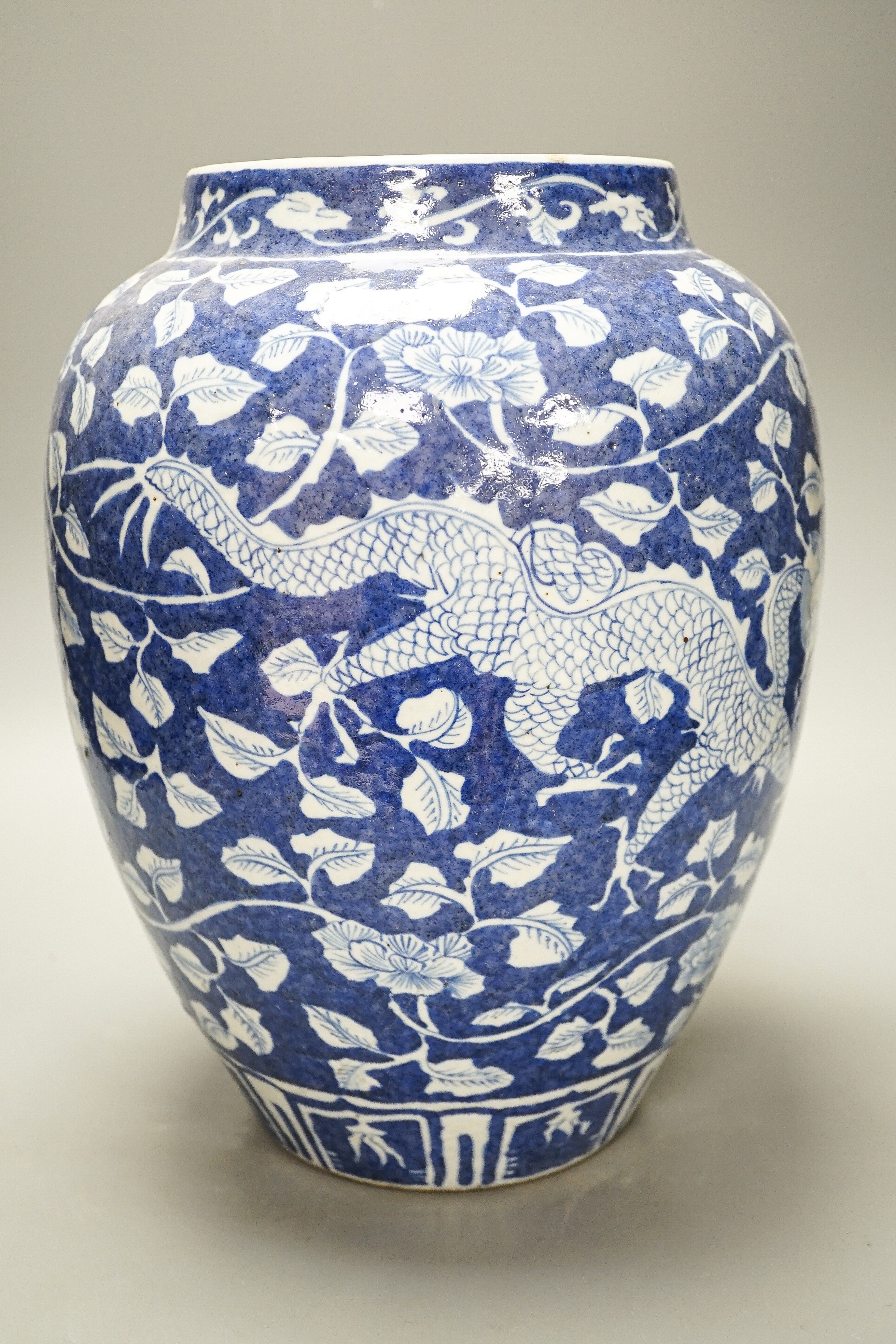 A Chinese blue and white ovoid jar, 19th/20th century, painted with dragons amid flowers and foliage, 33 cms high.